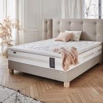 Un matelas en âme Hybride avec un sommier et tête de lit en beige.